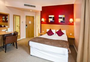 Un pat sau paturi într-o cameră la OYO Luton Hotel