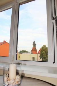 a window with a candle and a view of a building at Golden Dune Apartment in Klaipėda