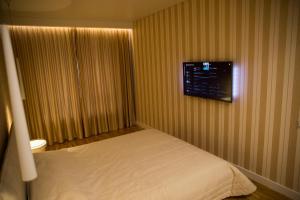 a bedroom with a bed and a television on the wall at Antakalnis 5 stars apartment in Vilnius