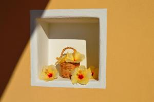 una cesta con flores en un marco blanco en una pared en Orizzonte Relais en Leni