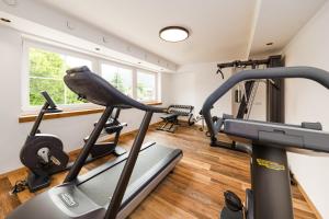einen Fitnessraum mit zwei Laufbändern und einem Laufband in der Unterkunft Hotel Bräurup in Mittersill