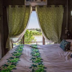 um quarto com uma cama e uma janela grande em Falik Farm Stay em Phra Nakhon Si Ayutthaya