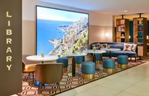 a rendering of a hotel lobby with tables and chairs at Aparthotel Adagio Monaco Monte Cristo in Beausoleil