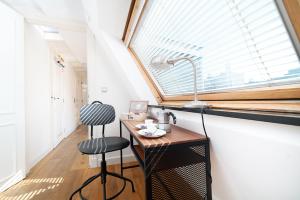 een keuken met een bureau, een wastafel en een raam bij Dase Maison B&B centrum in Amsterdam