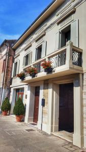 a white building with flowerpots on the front of it at Villa Cavour in Comacchio