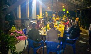 a group of people sitting at a table in a restaurant at Le Papayer Écolodge in Boukot Ouolof