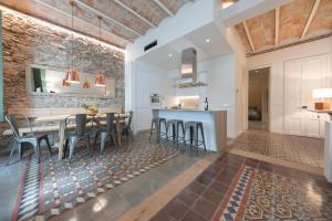 a kitchen and dining room with a table and stools at Bravissimo Mercaders, beautiful 3 bedroom apartment in Girona