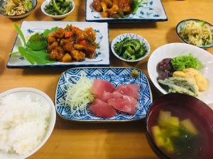 einen Tisch voller Teller mit Lebensmitteln mit Reis und Gemüse in der Unterkunft Minshuku Kuroshima in Kuroshima
