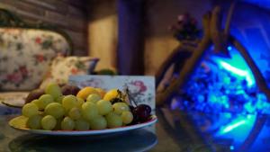 a plate of grapes on a table in a room at Ashash House in ‘Akko