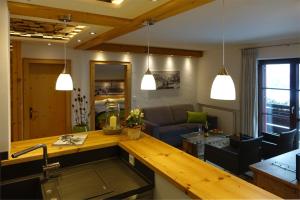 a kitchen with a sink and a living room at Ferienwohnungen Schmidbauer in Fischen