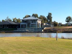 una casa sentada a un lado de un lago en Lake Resort on Black Bull, en Yarrawonga