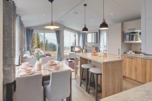 a kitchen and dining room with a table and chairs at Platinum Holiday Caravan in Bothel
