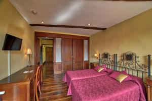 a bedroom with a large bed with pink sheets at PR Santo Grial in Santiago de Compostela