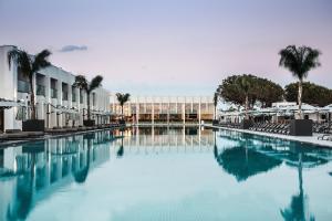 a swimming pool with palm trees and a building at Paloma Finesse Side in Side