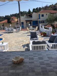 a patio with chairs and tables and an umbrella at Poseidon in Stafylos