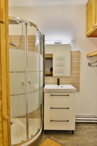 Un baño con ducha de cristal y lavabo. en L'Aiglon, en Cauterets