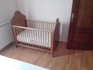 a crib in a room with a wooden floor at 1 Carrer de la Carrerada in Esterri d'Àneu