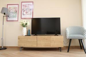 TV en un soporte de madera en la sala de estar en Archanda, apartamento en 1ª línea de playa, en Benidorm