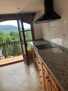 a kitchen with a counter top and a large window at CASA RUGALL in Monrós +20 photos