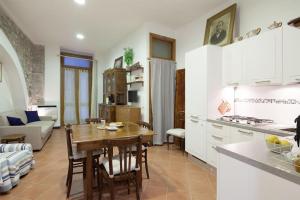 a kitchen and living room with a wooden table in a room at La Cantina di Lorenza in Vernazza +9 photos