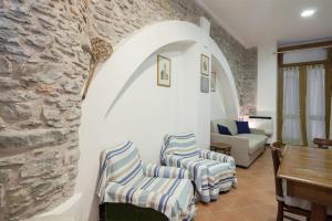 a living room with two chairs and a stone wall at La Cantina di Lorenza in Vernazza