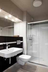 a bathroom with a toilet and a shower and a sink at Hotel Witkowski in Warsaw