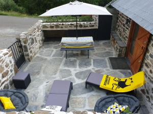 un patio con mesa, sillas y sombrilla en BERGERIE GRANGE DES 3 CIRQUES TROUMOUSE GAVARNIE ESTAUBE 4 personnes, en Gavarnie