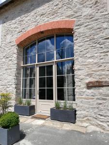 a window in a stone building with a white door at Gîte chezmadlou in Colondannes