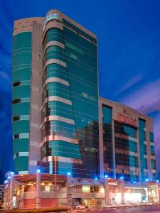a large building with blue lights in front of it at Deira Suites Deluxe Hotel Suites in Dubai