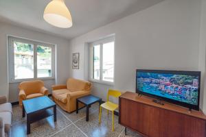 a living room with a flat screen tv and chairs at Cocca's House by PortofinoVip in Portofino