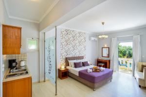 a bedroom with a bed and a kitchen with a sink at Poseidon Apartments in Kato Daratso