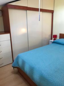 a bedroom with a bed with a blue comforter at Studio Apartman Lorenzo in Umag