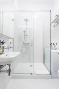 Un baño blanco con ducha y lavabo. en Gdynia Główna Apartments, en Gdynia 51 fotos más