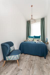 un dormitorio con una cama y una silla en Gdynia Główna Apartments, en Gdynia
