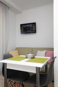 a dining room table with chairs and a white table at SunsetPeramos in Nea Peramos