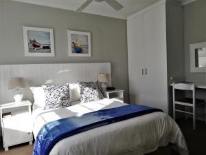 a bedroom with a large bed with blue and white sheets at Dolphin Inn Blouberg in Bloubergstrand