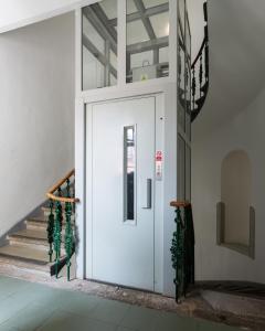 białe drzwi w budynku ze schodami w obiekcie City Center Cozy Apartments w Pradze