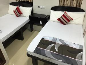 香港的住宿－天際賓館，配有白色床单的客房内的两张床