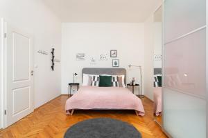 sypialnia z łóżkiem z różowym kocem w obiekcie City Center Cozy Apartments w Pradze