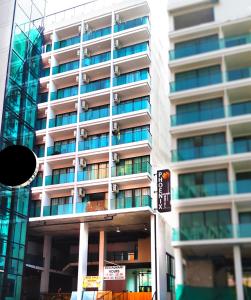 een hoog gebouw met een bord ervoor bij Phoenix Grand Patong in Patong Beach