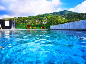 a swimming pool with two chairs in the water at Phoenix Grand Patong in Patong Beach