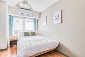 una camera da letto bianca con un letto e una finestra di Park Residence Omori a Tokyo