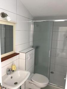 Un baño con inodoro, lavabo y ducha. en Rooms Kenedy, en Međugorje 24 fotos más