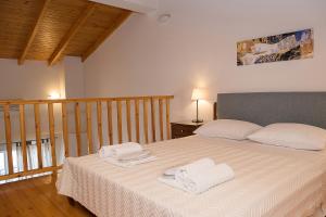 1 dormitorio con 1 cama con 2 toallas en Arcadian Apartments & Studios, en Xiropigado
