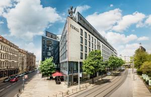 a tall building on a city street with cars at Penck Hotel Dresden in Dresden