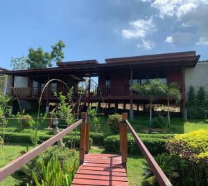 Maingern Maithong Resort في سارابوري: منزل أمامه جسر خشبي