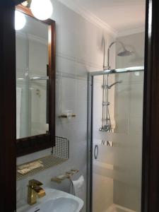 a bathroom with a sink and a shower with a mirror at Hotel Venta El Puerto in Murcia