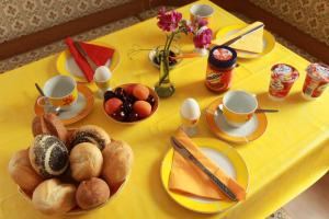 einen gelben Tisch mit Tellern und Tassen zum Frühstücken in der Unterkunft Ferienwohnung im Herzen des Nationalparks in Hohnstein + 4 Fotos
