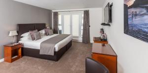 a hotel room with a bed and a television at La Barbarie Hotel by Eight Continents in St. Martin Guernsey +53 photos