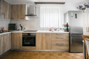 a kitchen with wooden cabinets and a stainless steel refrigerator at Matt's central place in Bled